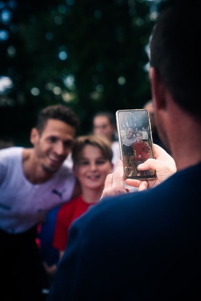 Impressionen: Ein Junge macht ein Erinnerungsfoto mit Dylan Borlee (O.E.H.) am 28.05.2022 waehrend der World Athletics Continental Tour IFAM Oordegem in Oordegem